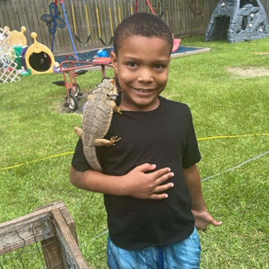 Small children playing with a lizard.